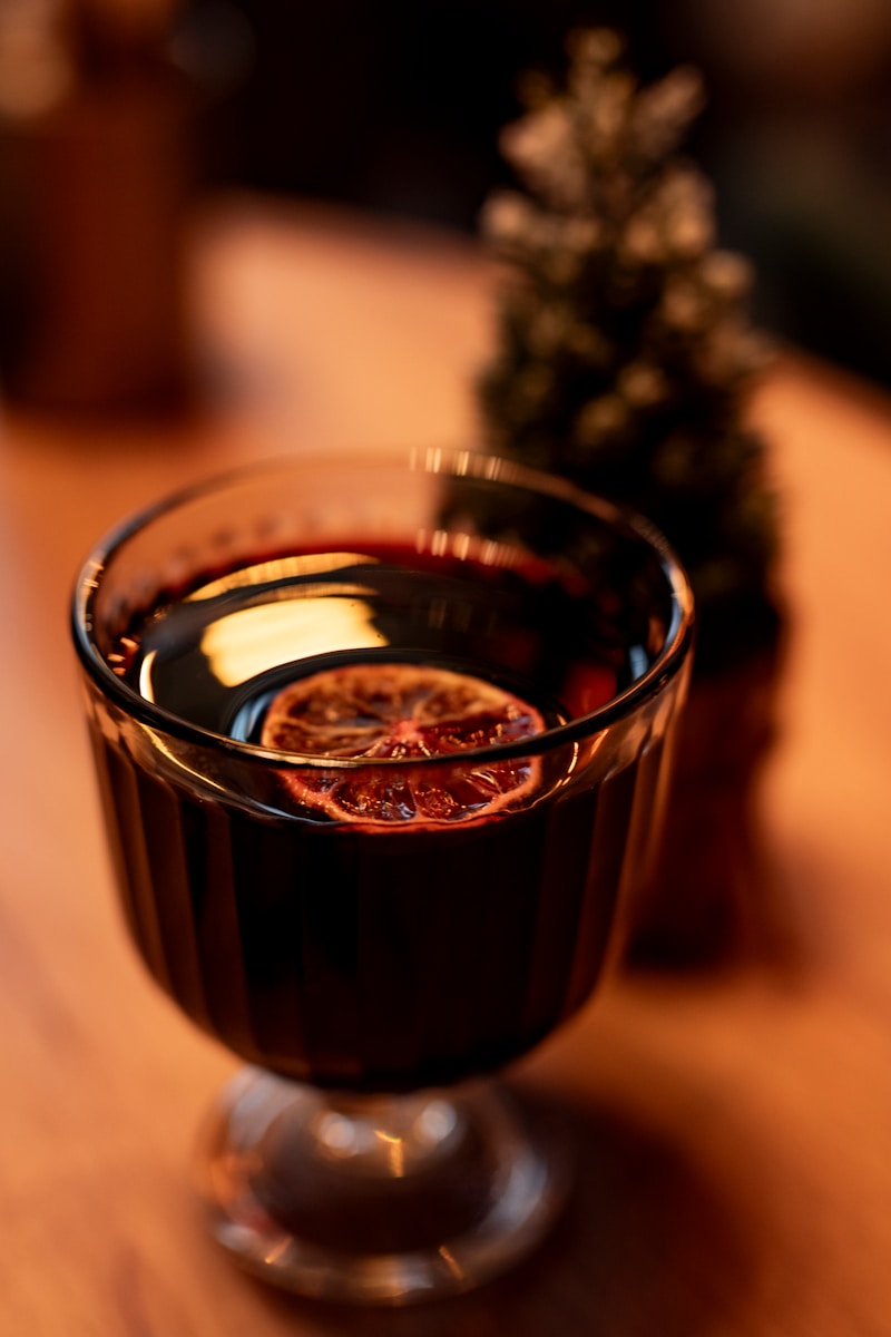 A glass filled with liquid sitting on top of a wooden table